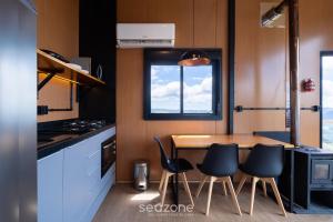 una pequeña cocina con mesa de madera y sillas en Cabaña con chimenea e hidromasaje! VST044, en Annitapolis