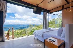 Un dormitorio con una cama y una ventana grande. en Cabaña con chimenea e hidromasaje! VST044, en Annitapolis