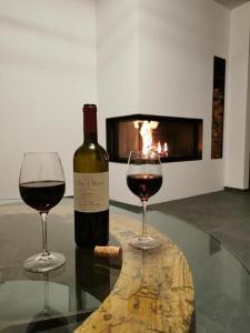 une bouteille de vin et deux verres sur une table dans l'établissement Chesa Andrea, Eg, à Pontresina