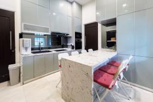 a kitchen with a counter with chairs around it at Luxury Villa Monterez Club Golf, Shah Alam - Smarthome in Shah Alam