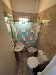 un piccolo bagno con un water e un lavandino di Hotel Abetaia a Villa Gesell