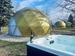 a tub with a bottle of wine in it next to a yurt at DayDreamer Domes in South Haven