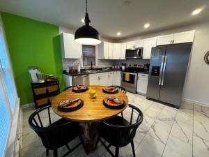 eine Küche mit einem Holztisch mit Stühlen und einem Kühlschrank in der Unterkunft La Casa Bella - 5 bedrooms in Louisville + 15 Fotos