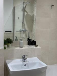 a white bathroom with a sink and a shower at Modern Refurbished Apt in Stevenage Town Centre in Stevenage