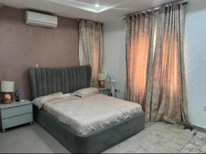 um quarto com uma cama e uma janela em Epic Apartment em Abuja