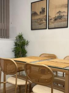 a wooden table with chairs and pictures on the wall at Modern Refurbished Apt in Stevenage Town Centre in Stevenage