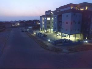 a parking lot next to a building at night at Epic Apartment in Abuja