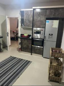 uma cozinha com geladeira e fogão forno superior em Epic Apartment em Abuja