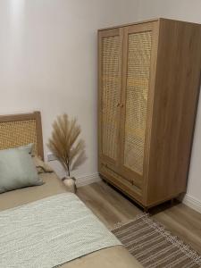 a bedroom with a large wooden cabinet next to a bed at Modern Refurbished Apt in Stevenage Town Centre in Stevenage +1 photo