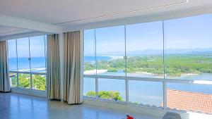 um quarto com uma grande janela com vista para a água em Cobertura com vista panorâmica, piscina, garagem e churrasqueira em Barra de Guaratiba