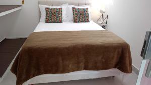 uma cama grande com um cobertor castanho e almofadas em Cobertura com vista panorâmica, piscina, garagem e churrasqueira em Barra de Guaratiba mais 30 fotografias