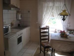 a kitchen with a table and a chair and a window at Große Ferienwohnung Mit Balkon Und Garten in Steinen