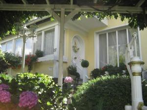 a yellow house with flowers in front of it at Große Ferienwohnung Mit Balkon Und Garten in Steinen