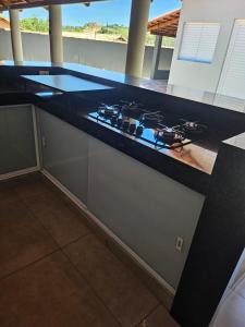 a kitchen with a black counter top with a stove at Casa do Weber, Jardim Acacias in São João Batista do Glória