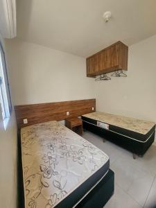 a room with two beds in a room at Casa do Weber, Jardim Acacias in São João Batista do Glória