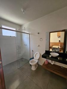 a bathroom with a toilet and a sink and a mirror at Casa do Weber, Jardim Acacias in São João Batista do Glória +44 photos