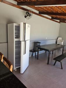 a kitchen with a refrigerator and a dining table at Casa do Weber, Jardim Acacias in São João Batista do Glória