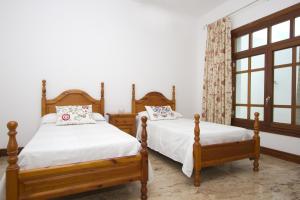 une chambre avec deux lits et une fenêtre dans l'établissement Ruhiges Landhaus Remedios Mit Panoramablick, à Los Valles