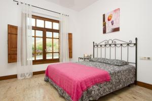 une chambre avec un lit avec une couverture rose dans l'établissement Ruhiges Landhaus Remedios Mit Panoramablick, à Los Valles