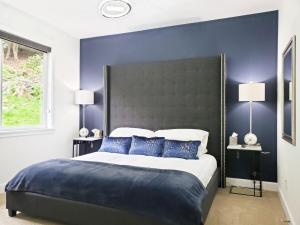 a bedroom with a large bed with blue walls at Eaglemont Golf Course Peaceful Retreat in Mount Vernon