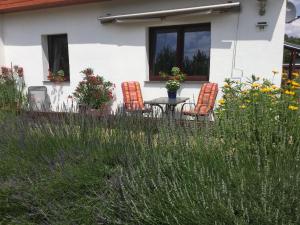 3 chaises et une table devant une maison dans l'établissement Kleines Ferienhaus In Rangsdorf Mit Großem Garten, à Rangsdorf