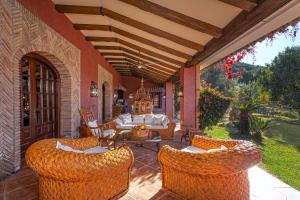 eine Außenterrasse mit Korbstühlen und einem Sofa in der Unterkunft Ferienhaus für 12 Personen in Alcaucín, Andalusien Costa del Sol - b61173 in Alcaucín