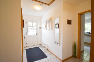 un couloir avec une porte blanche et un miroir dans l'établissement Nordlicht, à Steinbergkirche