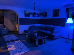 a blue living room with a couch and a table at Central Villa in Craiova