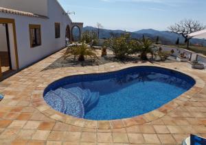 a swimming pool in a patio with a house at Casa Siete Arcos in Sedella