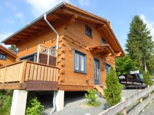 eine Blockhütte mit einer Veranda und einer Terrasse in der Unterkunft Harz - Blockhaus, 4 und 5 Sterne Blockhäuser, Sauna und Kamin, RH in Hahnenklee-Bockswiese