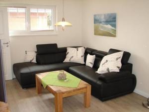 a living room with a black couch and a table at Ferienhaus In Winnemark Mit Großem Garten in Winnemark