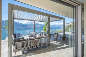 an open patio with a view of the water and mountains at Alleinstehende Villa Mit Pool Und Traumaussicht in Castelletto di Brenzone