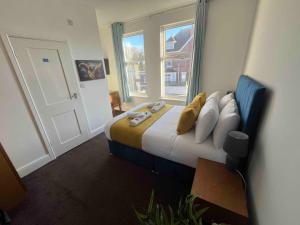 ein Schlafzimmer mit einem Bett mit Kissen und einem Fenster in der Unterkunft The Linden Leaf Rooms in Nottingham