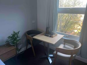 ein Raum mit einem Tisch und zwei Stühlen und einem Fenster in der Unterkunft The Linden Leaf Rooms in Nottingham + 13 Fotos