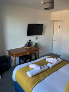 ein Schlafzimmer mit einem Bett mit zwei Handtüchern darauf in der Unterkunft The Linden Leaf Rooms in Nottingham