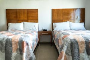 Dos camas una al lado de la otra en una habitación. en Hotel Suites Gaby, en Cancún