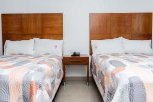 Dos camas una al lado de la otra en un dormitorio. en Hotel Suites Gaby, en Cancún