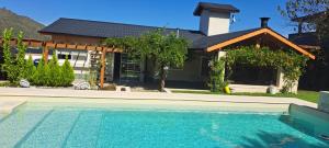 a house with a swimming pool in front of a house at Casa con encanto serrano in Villa General Belgrano