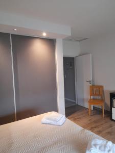 a bedroom with a white bed and a chair at Casa con encanto serrano in Villa General Belgrano +9 photos