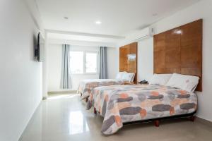 a bedroom with two beds and a window at Suites Gaby Cancun in Cancún +68 photos