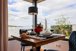 einen Tisch mit Weingläsern und Blumen am Fenster in der Unterkunft Ferienhaus für 2 Personen ca 43 qm in Algarvia, Azoren Sao Miguel in Algarvia