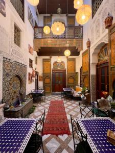 ein Raum mit Tischen und Stühlen in einem Gebäude in der Unterkunft Riad Alma fes in Fès
