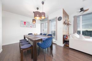 a dining room with a table and blue chairs at Sub-Penthouse Condo with Jacuzzi Pool Sauna & Gym in Vancouver