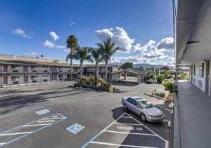 a car parked in a parking lot in front of a building at Steinbeck Lodge in Salinas