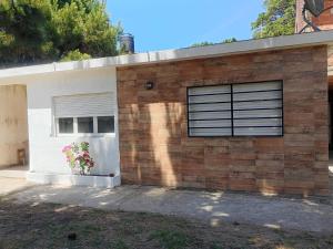 a brick house with a window and a garage at Il Giardino de Santa in Santa Teresita