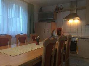 eine Küche mit einem Holztisch und Stühlen sowie einem Tisch und einer Küche in der Unterkunft Ferienwohnung für 2 - 5 Personen mit zwei getrennten Schlafzimmern in Saas-Almagell + 16 Fotos