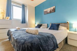 deux lits dans une chambre aux murs bleus dans l'établissement Central 2Bed,2Bath, Balcony Apartment Near New Street, Mailbox & Canals at Skyline Apartments, à Birmingham
