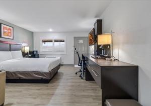 a hotel room with a bed and a desk at Steinbeck Lodge in Salinas