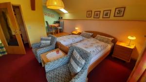 une chambre d'hôtel avec deux lits et un canapé dans l'établissement Ferienwohnung In Bayerisch Eisenstein Mit Garten, à Bayerisch Eisenstein