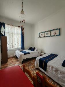 une chambre avec deux lits et un lustre dans l'établissement Hostal Vicmar, à Viña del Mar